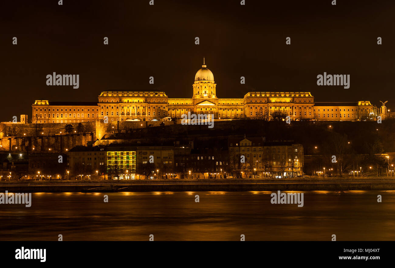 Il Castello di Buda (Palazzo Reale) dal fiume Danubio illuminata di notte a Budapest, Ungheria Foto Stock