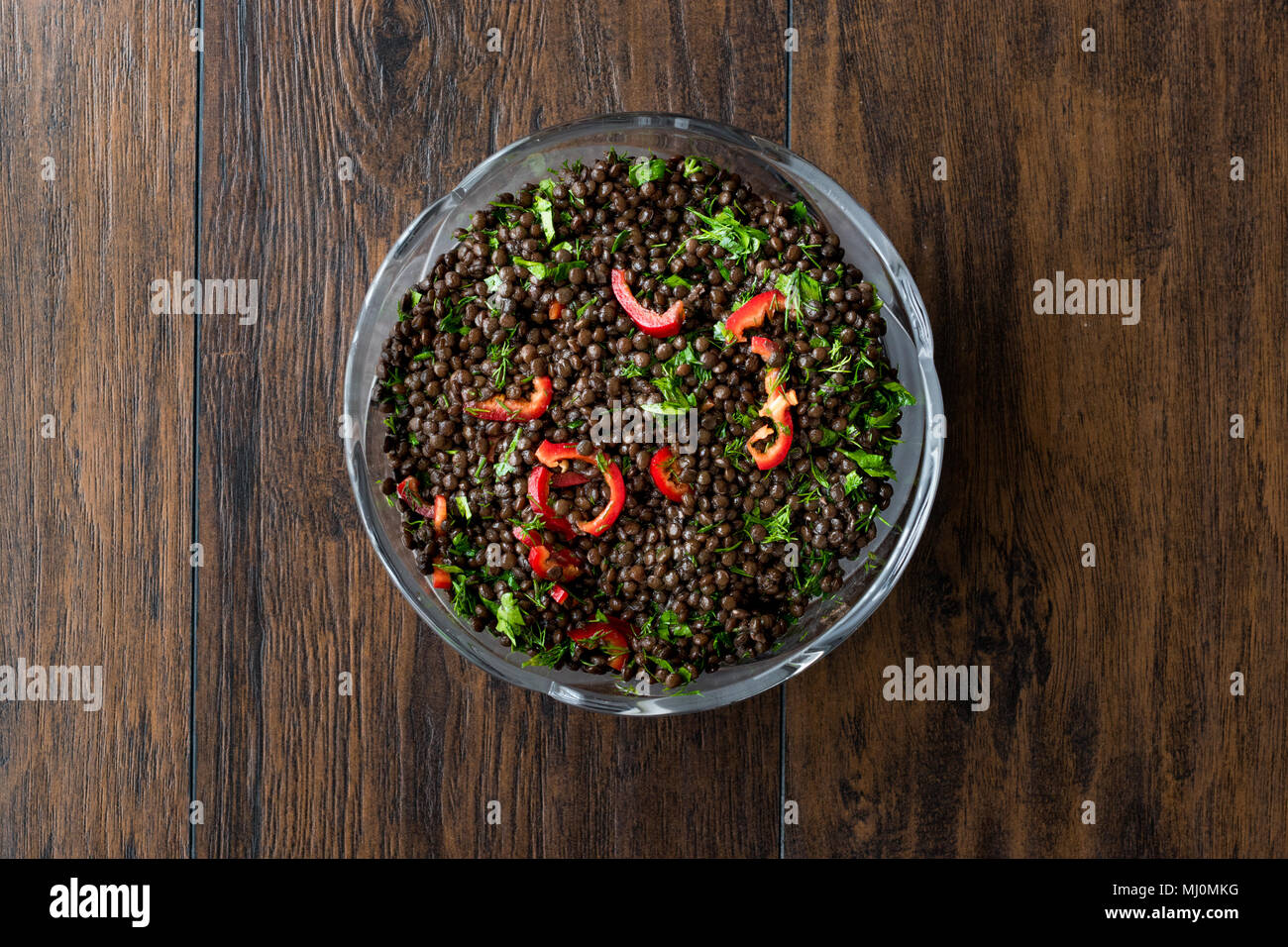 Nero insalata di lenticchie con peperoncino e prezzemolo. Alimenti biologici. Foto Stock