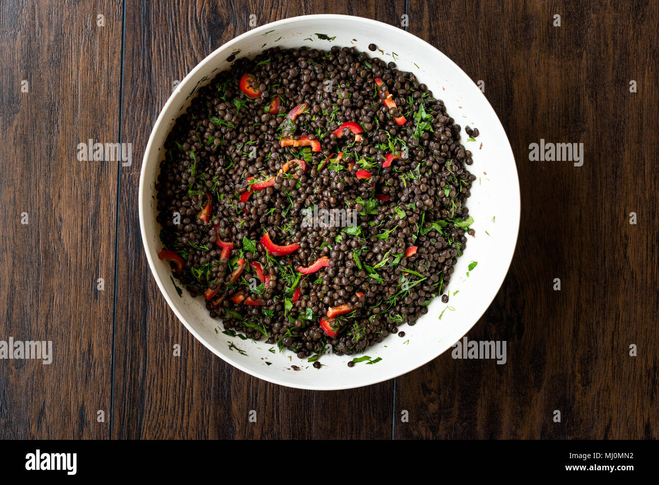 Nero insalata di lenticchie con peperoncino e prezzemolo. Alimenti biologici. Foto Stock