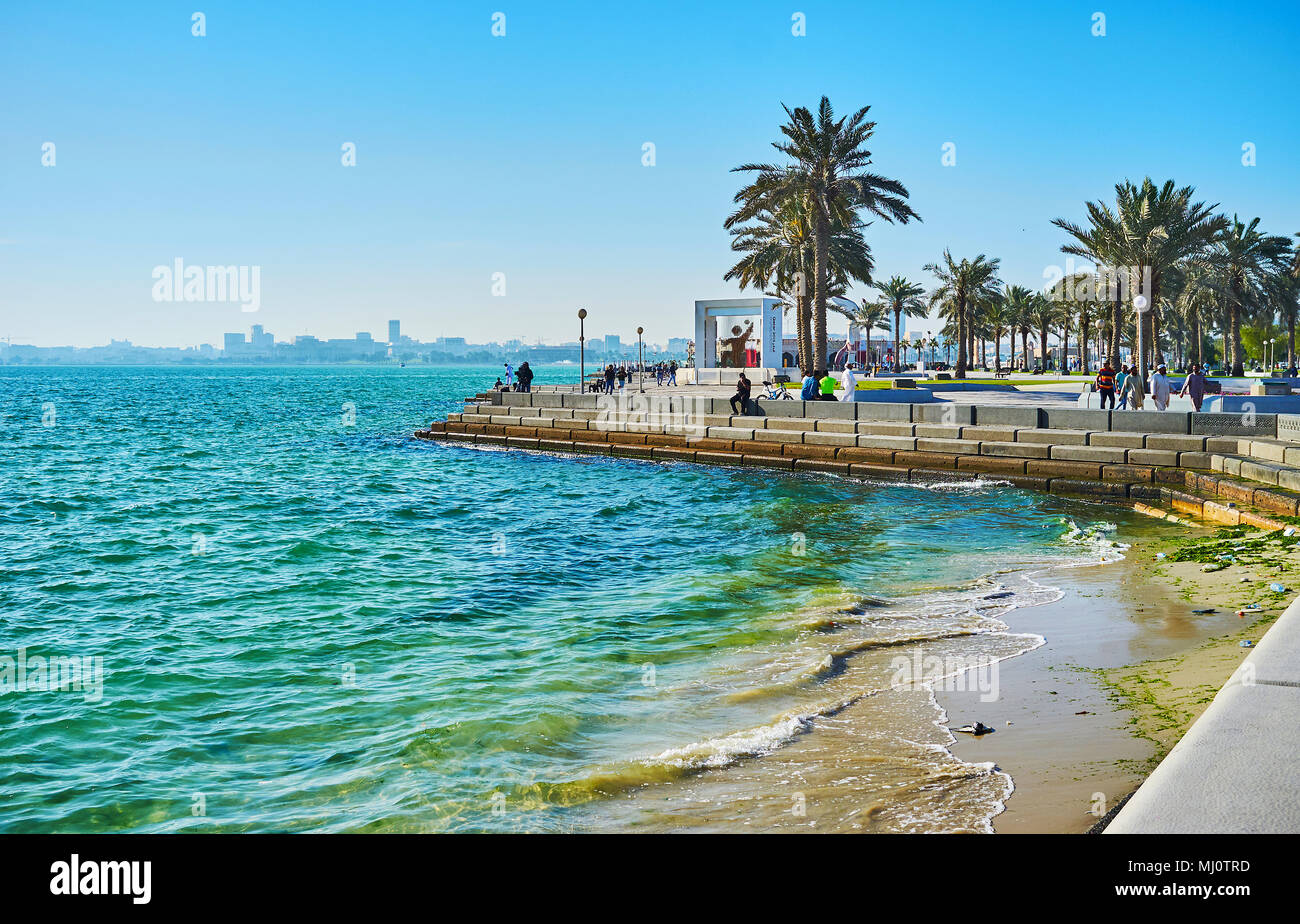 DOHA, Qatar - 13 febbraio 2018: scenic seascape dalla corniche Promenade con vista sul verde delle palme e dolci onde, West Bay, il 13 febbraio Foto Stock