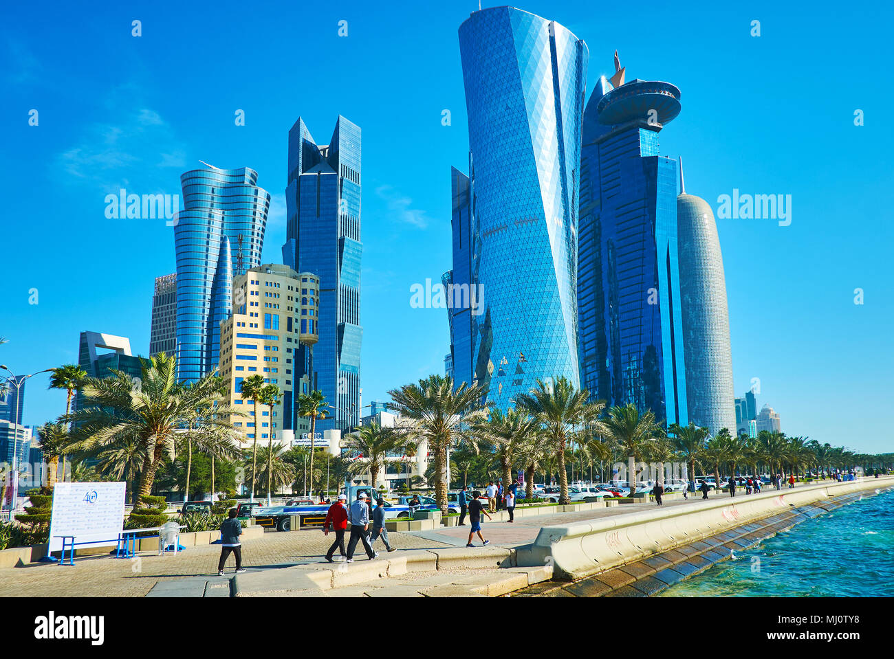 DOHA, Qatar - 13 febbraio 2018: Al i quarti di Al Dafna district con Brillanti grattacieli di vetro e la fila di lussureggianti palme lungo la Corniche pr Foto Stock