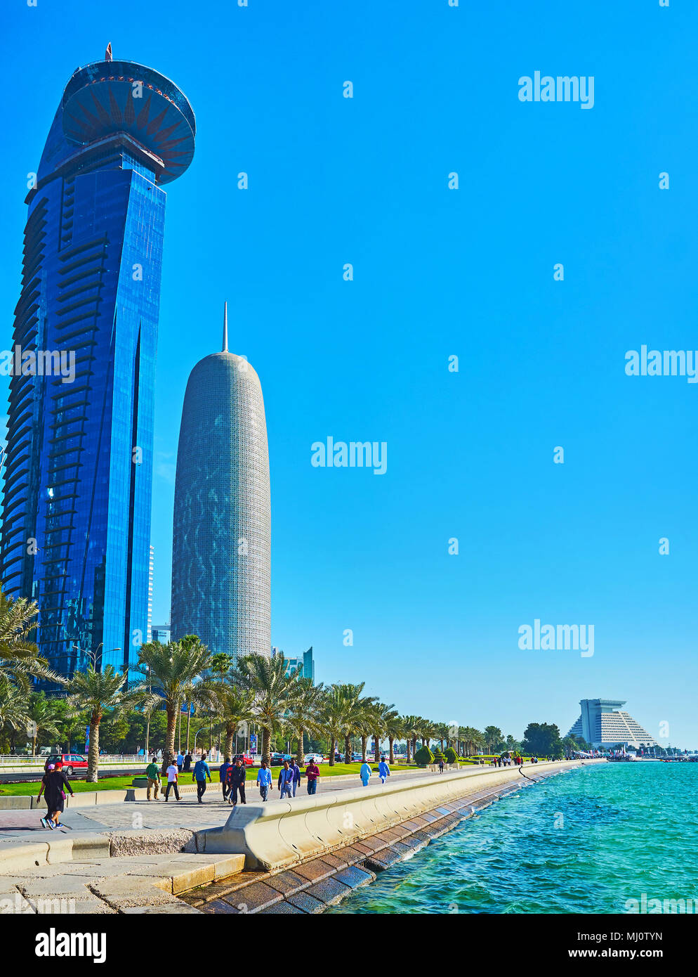 DOHA, Qatar - 13 febbraio 2018: al lungomare Corniche con la linea verde di palme, allungandosi lungo il vetro grattacieli di business al Dafna distretto, Foto Stock