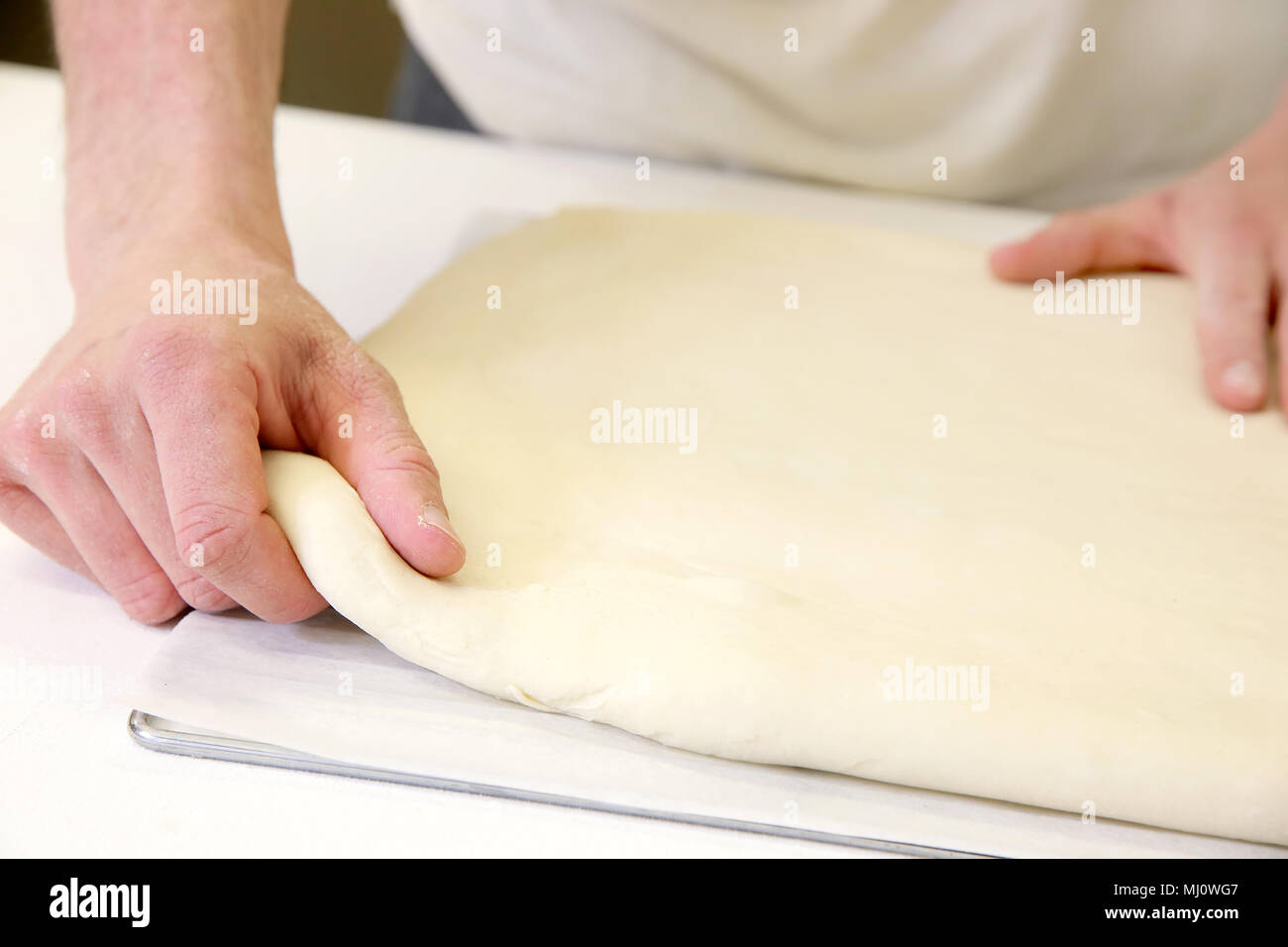 Produrre un impasto da mani maschio al forno Foto Stock