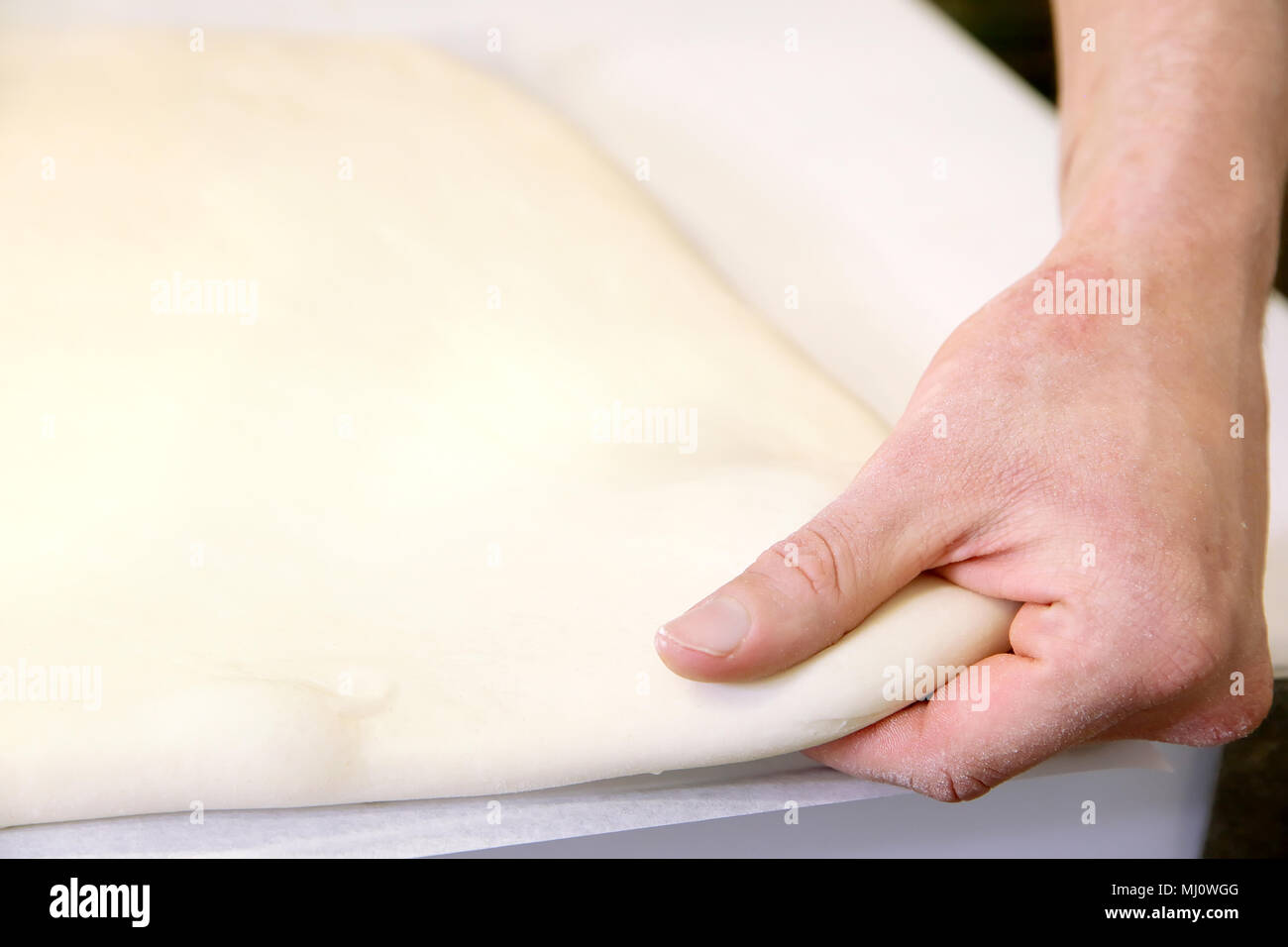 Produrre un impasto da mani maschio al forno Foto Stock