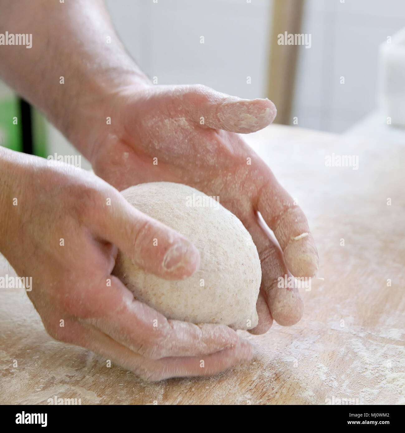Produrre un impasto da mani maschio al forno Foto Stock