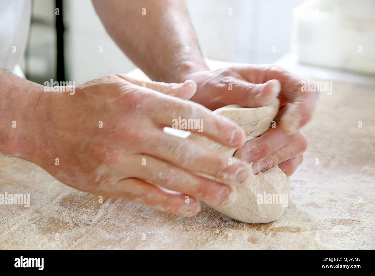 Produrre un impasto da mani maschio al forno Foto Stock