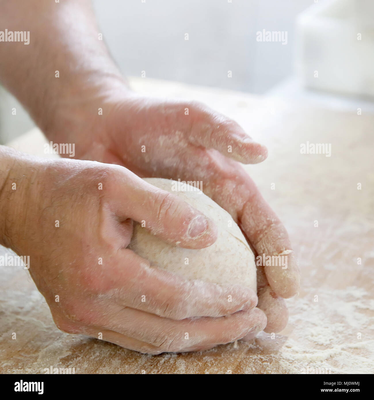 Produrre un impasto da mani maschio al forno Foto Stock