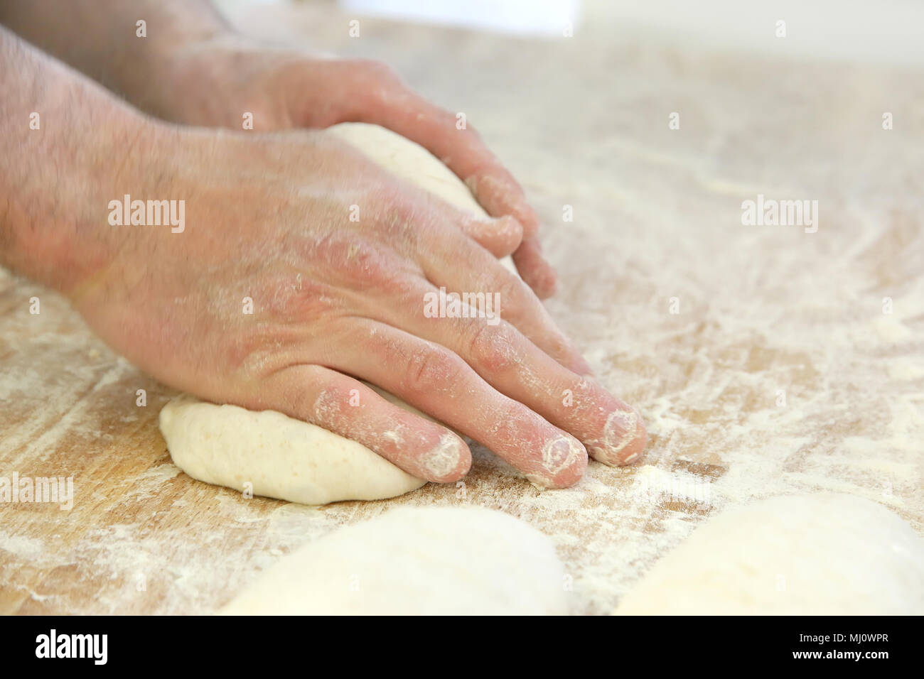 Produrre un impasto da mani maschio al forno Foto Stock