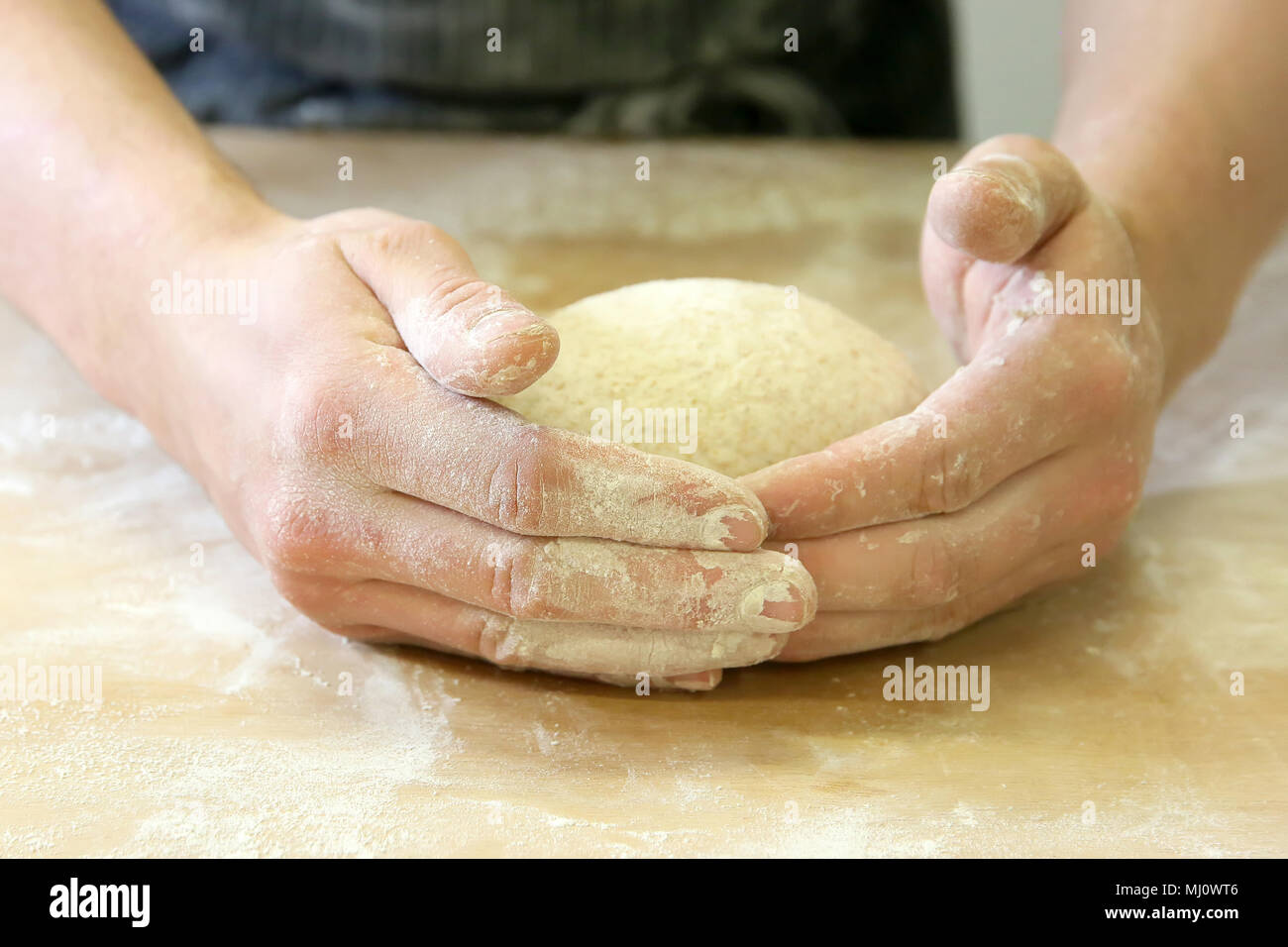 Produrre un impasto da mani maschio al forno Foto Stock
