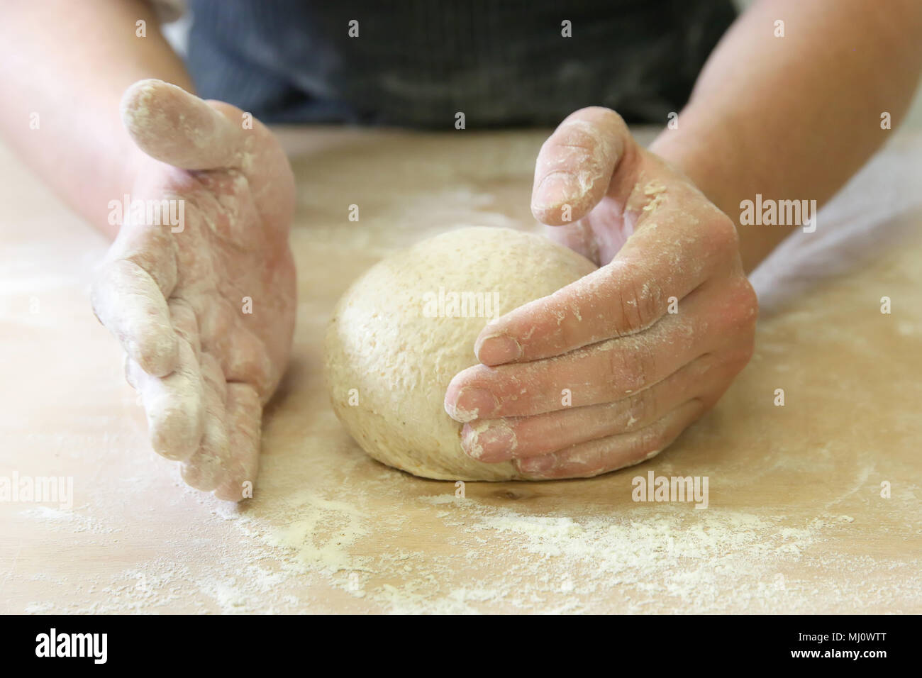 Produrre un impasto da mani maschio al forno Foto Stock