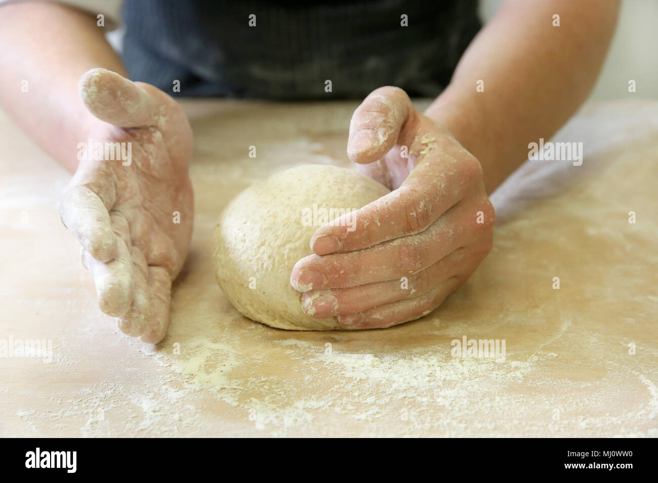 Produrre un impasto da mani maschio al forno Foto Stock
