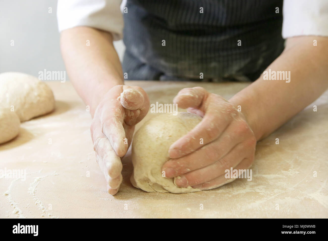 Produrre un impasto da mani maschio al forno Foto Stock