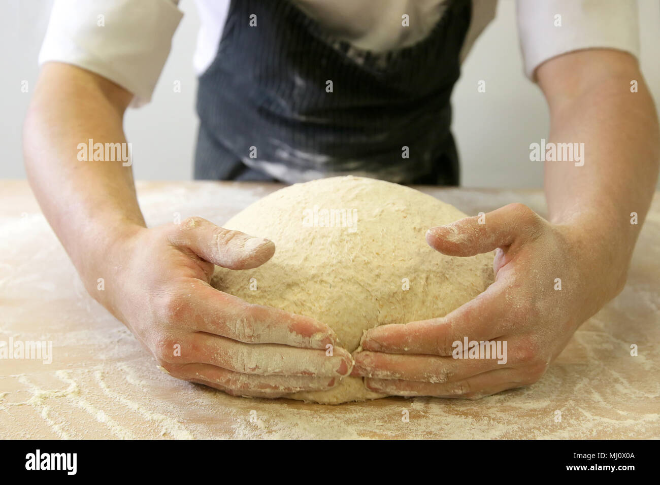 Produrre un impasto da mani maschio al forno Foto Stock
