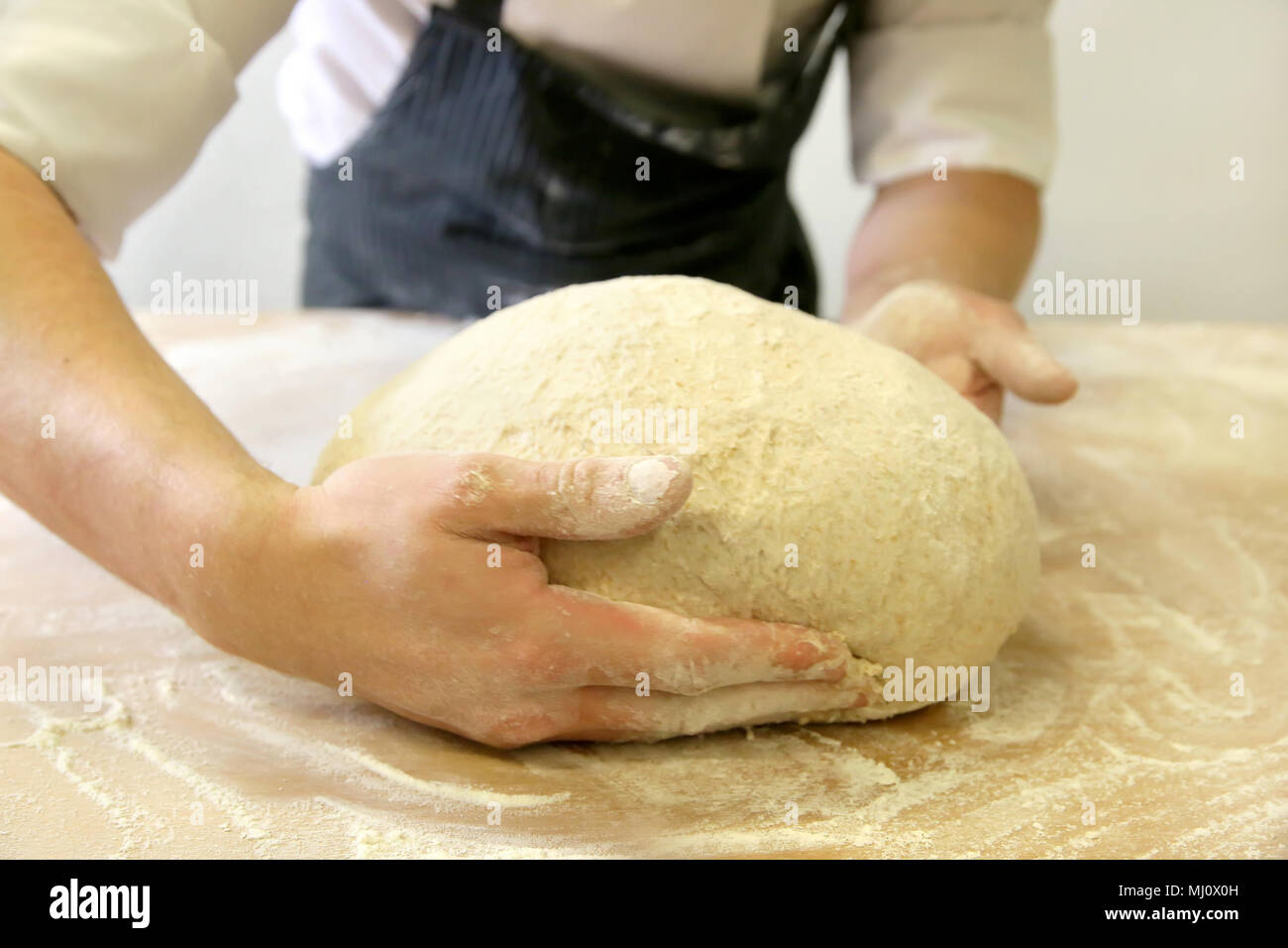 Produrre un impasto da mani maschio al forno Foto Stock