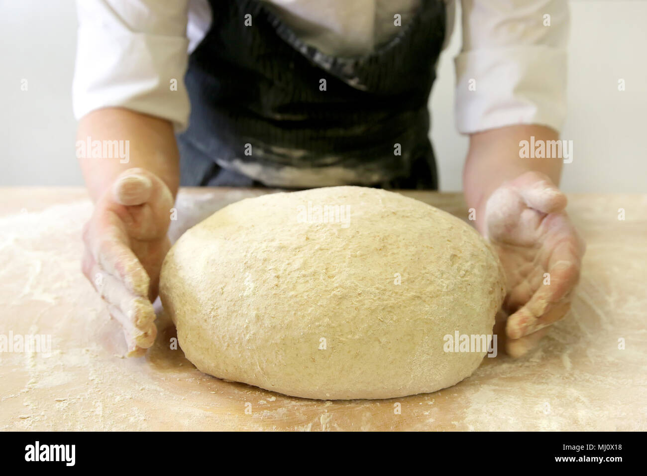 Produrre un impasto da mani maschio al forno Foto Stock