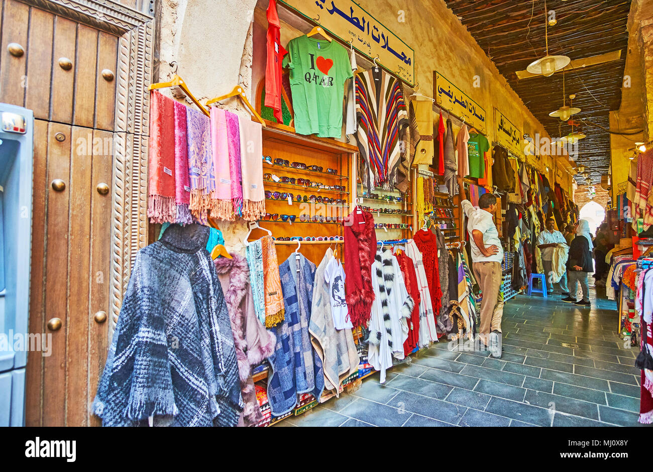 DOHA, Qatar - 13 febbraio 2018: negozi di Souq Waqif di solito posto le loro merci lungo la parete di facciata, così il vicolo diventa ancora più stretta di un Foto Stock