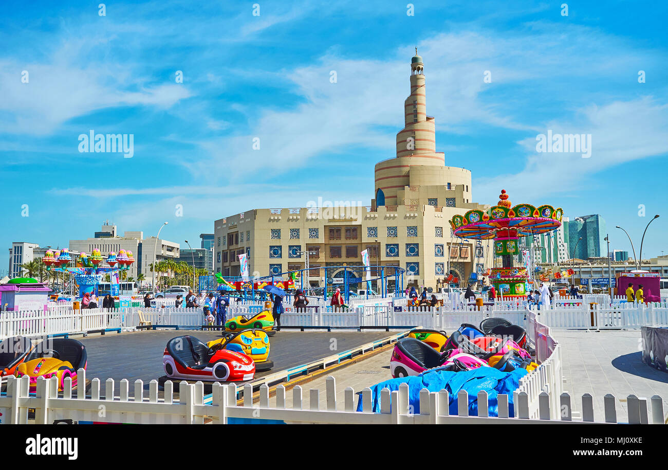 DOHA, Qatar - 13 febbraio 2018: Luna park per bambini con paraurti elettrico auto e giostre situato accanto al Souq Waqif e Fanar Moschea di Al Souq Foto Stock
