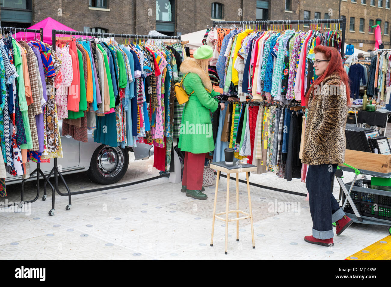 Vecchio vintage abiti femminili per la vendita su un rack a un retro vintage auto vendita di avvio. Granary Square, Kings Cross, London Foto Stock Vecchio vintage abiti femminili per la vendita su un rack a un retro vintage auto vendita di avvio. Granary Square, Kings Cross, London Foto Stock