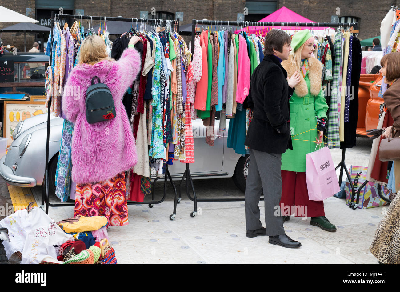 Vecchio vintage abiti femminili per la vendita su un rack a un retro vintage auto vendita di avvio. Granary Square, Kings Cross, London Foto Stock