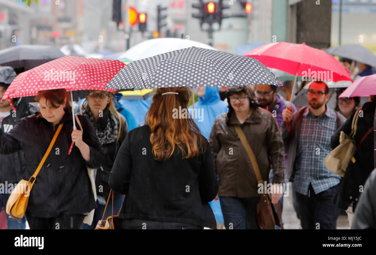 Stoccolma, Svezia - Luglio 29, 2015: Persone con ombrelloni a piedi nel quartiere centrale. Foto Stock