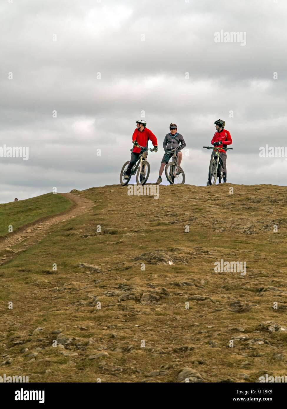 Gli uomini di sesso maschile off road mountain bike motociclisti indossano caschi ciclo di prendere un periodo di riposo mentre a cavallo della cresta lungo il Malvern Hills in Worcestershire Inghilterra REGNO UNITO Foto Stock