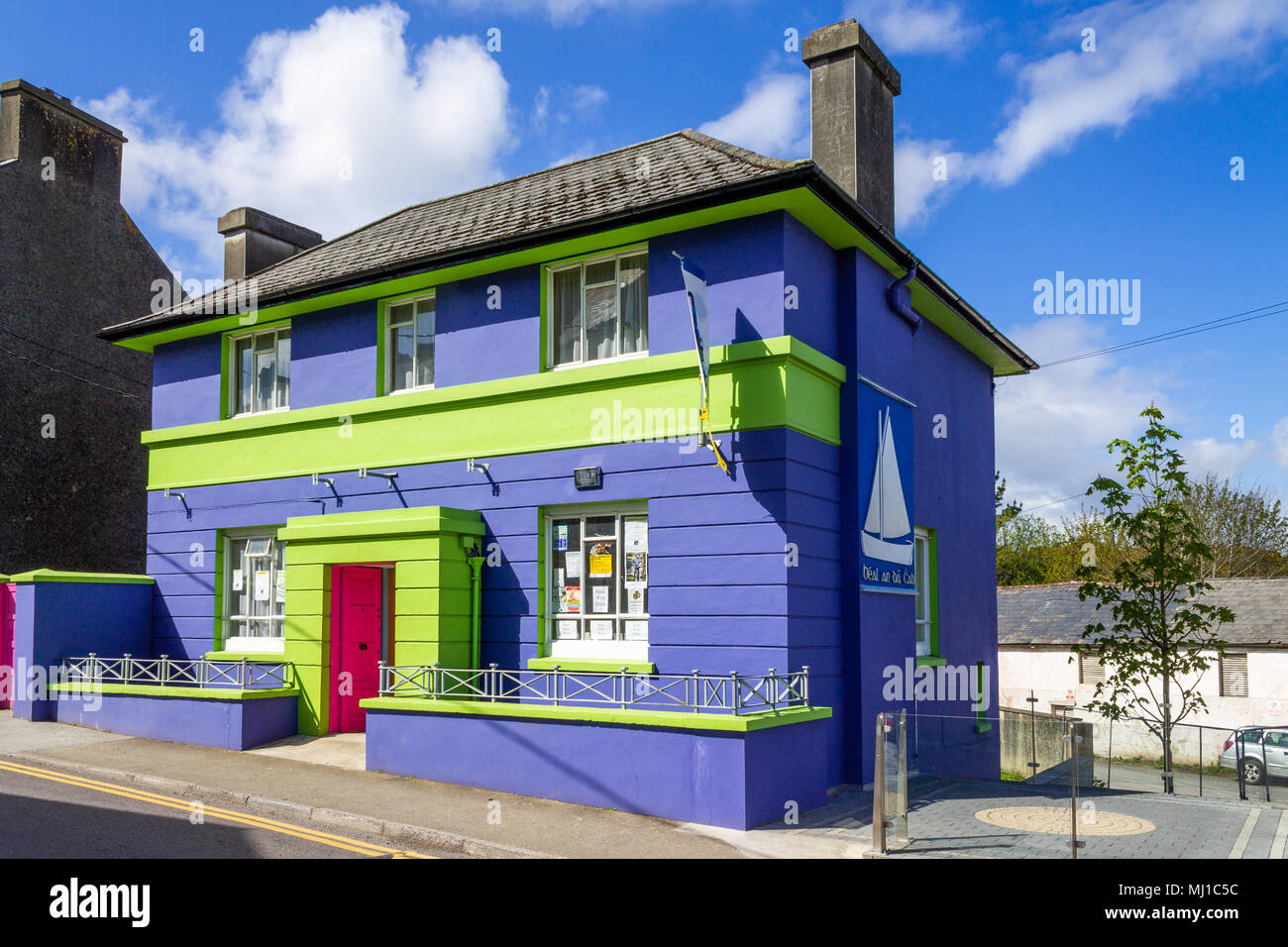 Edificio in mattoni vivacemente colorato o di colore azzurro intenso e verde , un domestico convertito casa in piedi fuori nel sole di mezzogiorno. Foto Stock