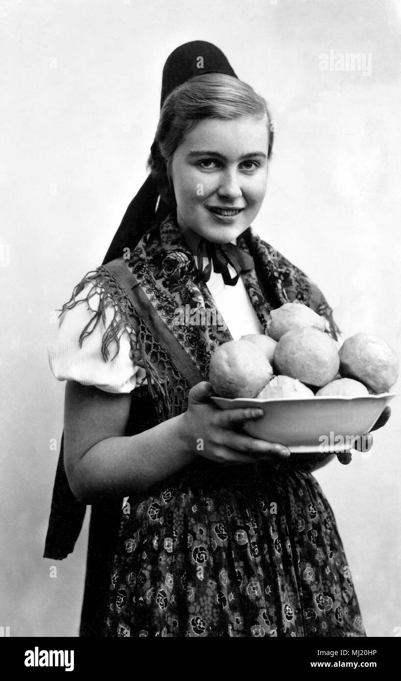 La donna nel tradizionale costume tradizionale con canederli, gnocchi, 1930, Germania Foto Stock