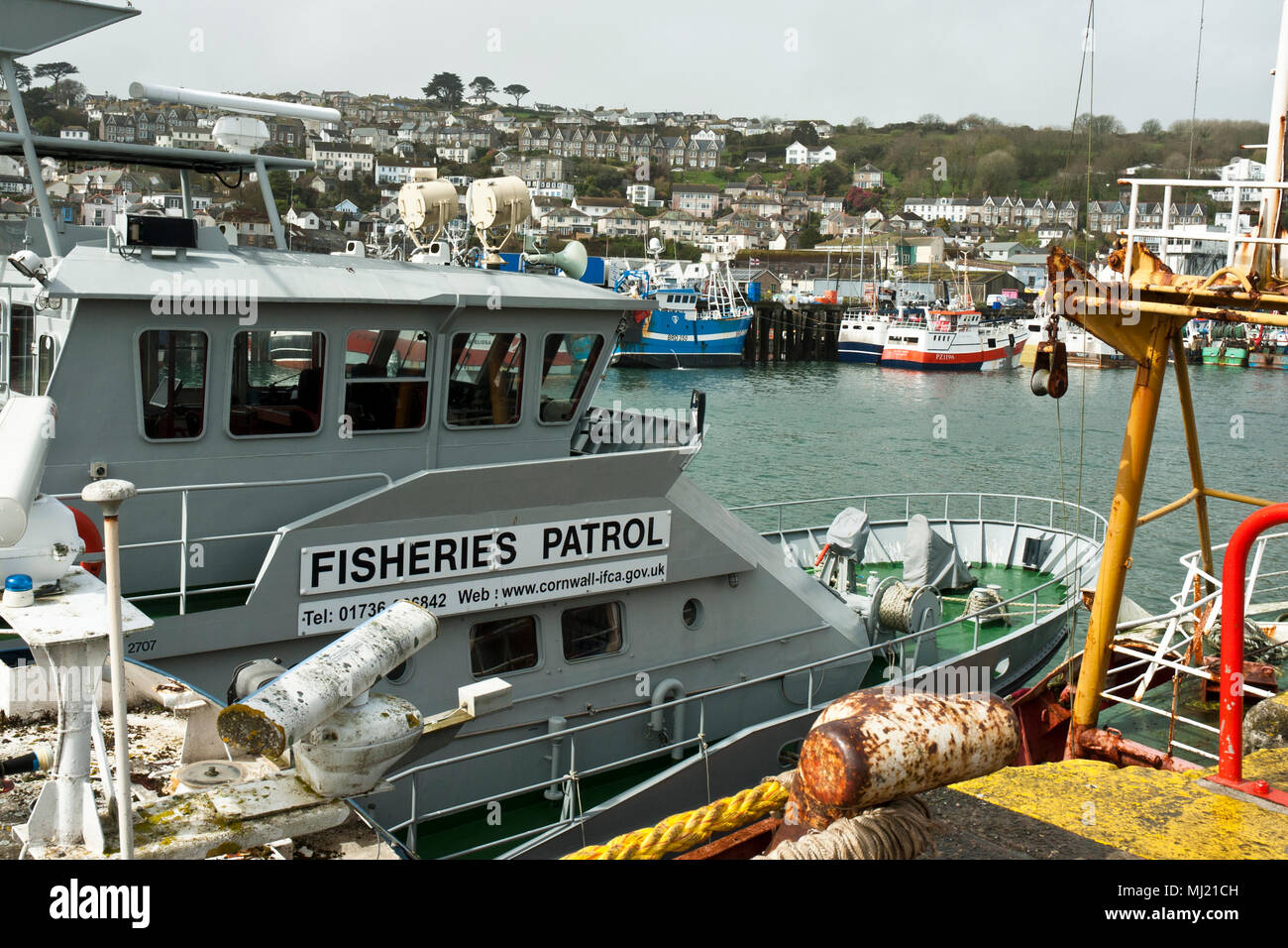 La pesca nave pattuglia, Saint Pirano, in primo piano con le barche dei pescatori e la città di Newlyn in background. Foto Stock