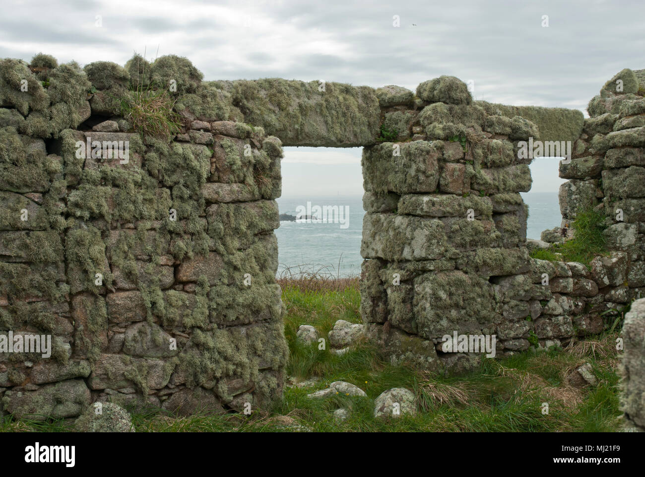 I resti di una casa ricoperta da licheni sull'ora isola disabitata di Sansone, il mare può essere visto attraverso la porta e finestra. Isole Scilly. Foto Stock