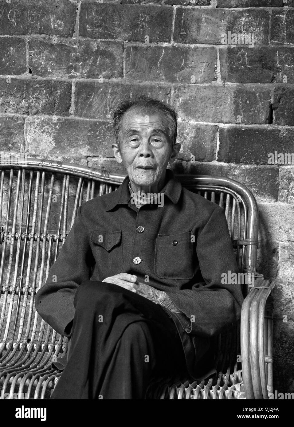 Il vecchio uomo in uno dei round earth case del popolo Hakka, provincia del Fujian, Cina Foto Stock