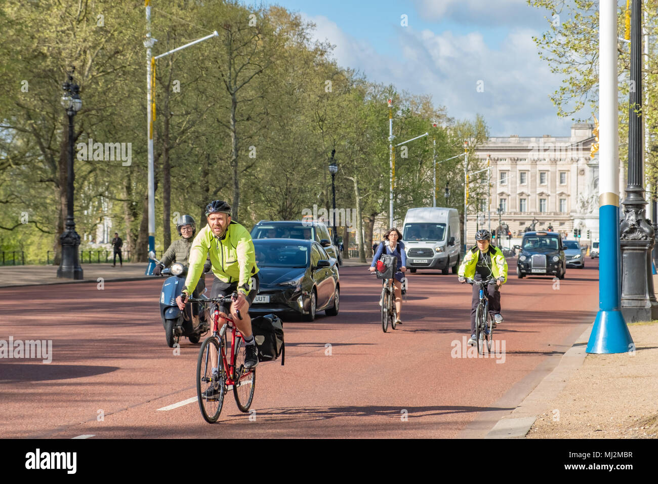 I ciclisti e automobili condividono la strada e il centro commerciale di Londra vicino a Buckingham Palace. Foto Stock