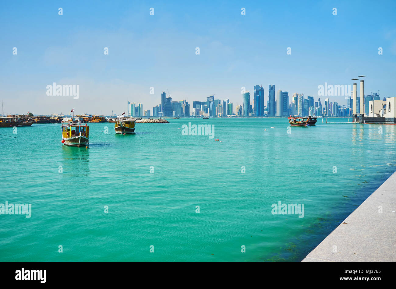 Il Corniche promenade apre la vista sul lungomare, crociera barche e moderni grattacieli di West Bay, a Doha, in Qatar. Foto Stock