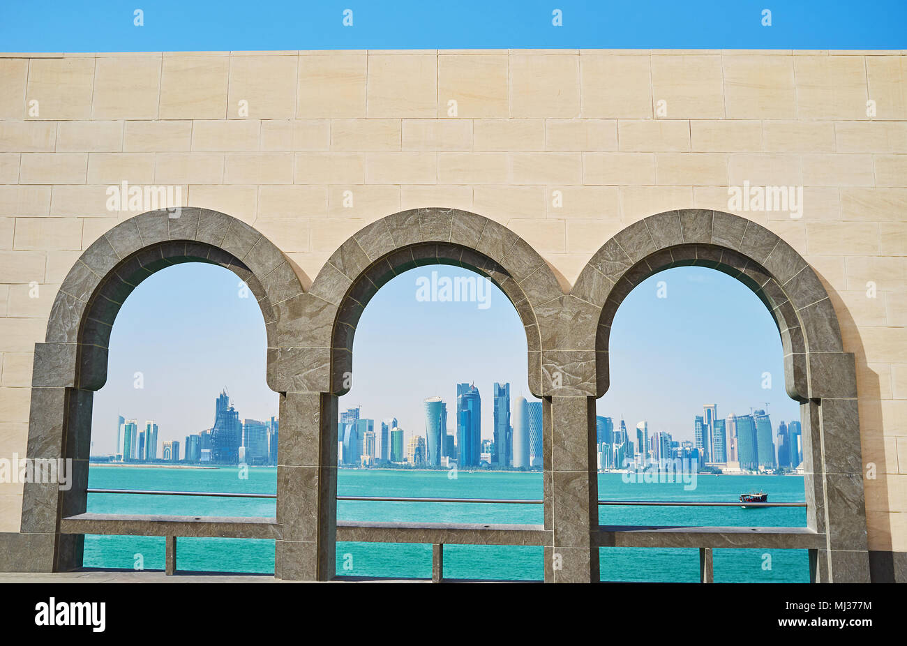 Il pittoresco paesaggio marino con grattacieli futuristici di Al Dafna distretto attraverso la pietra finestre ad arco, Doha, Qatar. Foto Stock