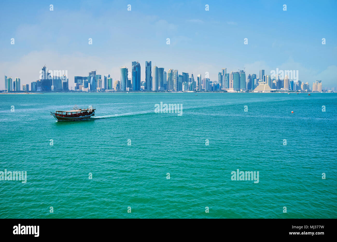 L'imbarcazione da diporto nelle acque del Golfo Persico con moderno distretto di West Bay con vetro futuristici grattacieli sullo sfondo, Doha, Qatar. Foto Stock