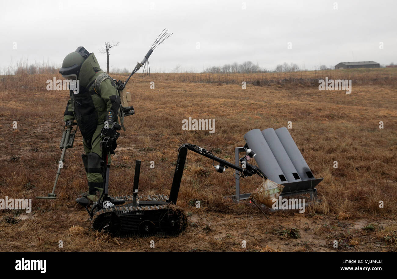 Il personale Sgt. Jason McClure, un'eliminazione degli ordigni esplosivi team leader con 717th Ordnance Company (l'eliminazione degli ordigni esplosivi), 184Ordnance battaglione (EOD), 52nd Ordnance Gruppo (EOD), XX chimici, biologici, radiologici, nucleari e ad alta resa comando esplosiva, utilizza un rivelatore di metalli nei pressi di un razzo simulato di posizione di sparo per verificare la presenza di ulteriori pericoli per la formazione professionale in settori di Fort Campbell, Ky., 22 febbraio, 2018. Questa simulazione è stata parte del multi-echelon esercizio di allenamento per il gruppo e comprendeva un esercizio di convalida per la società per la sua imminente la distribuzione in Asia sud-ovest. (U.S Foto Stock