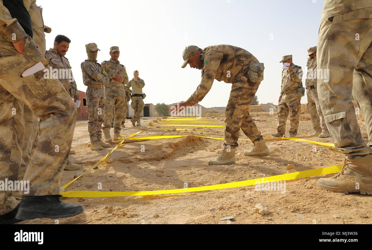 Un iracheno guardia di confine vigore istruttore dimostra tecniche adeguate per identificare sepolto ordigni esplosivi artigianali di soldati iracheni a Camp Al Asad, Iraq, Marzo 20, 2018. Il curriculum a rafforzare la capacità del partner sites include: leadership, etica e diritto di guerra la formazione e le istruzioni. Inoltre, le reclute sono insegnate navigazione terrestre, formazione di base di medico, fanteria le competenze e la piccola unità tattica. (U.S. Immagine dell'esercito collezione che celebra il coraggio di impegno di dedizione e di sacrificio di U.S. Forze Armate e personale civile. Foto Stock