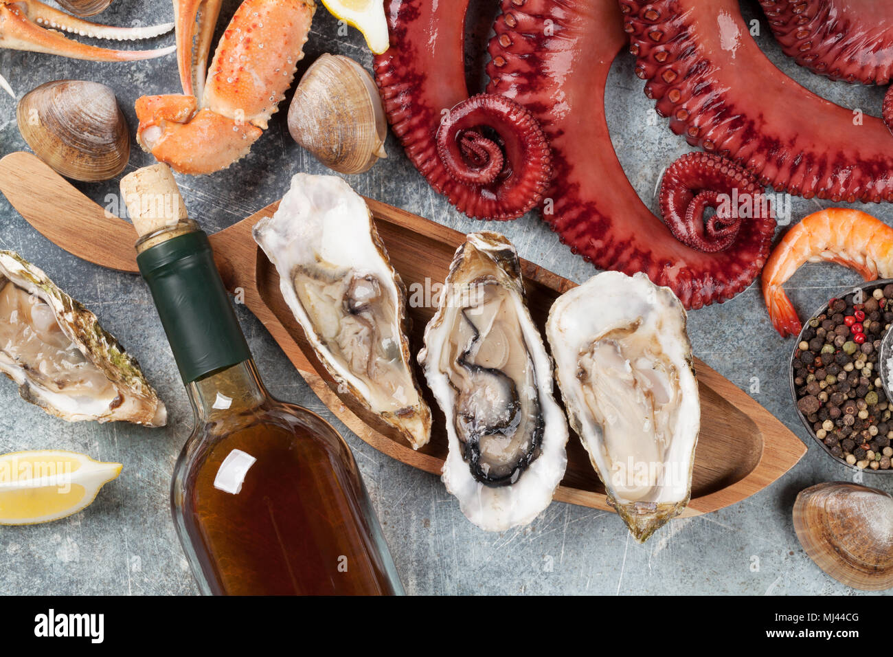 Piatti a base di frutti di mare e vino bianco. Il polpo, ostriche, aragosta, vongole. Sul tavolo di pietra Foto Stock