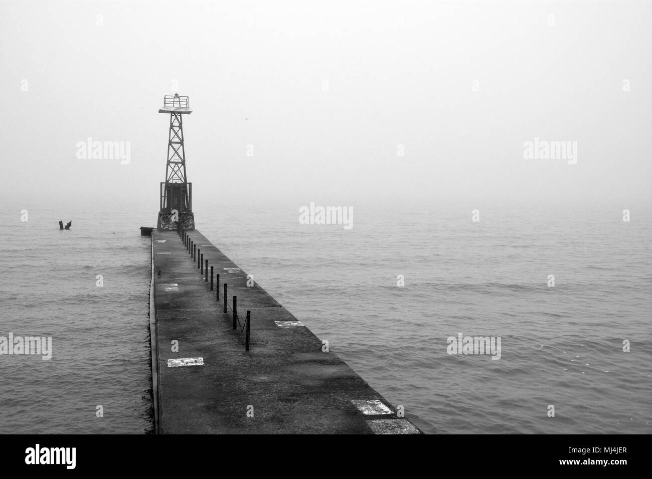 La nebbia e la pioggia di creare condizioni di scarsa visibilità al Foster Avenue beach break di segnale a parete torre sul Lago Michigan a Chicago il lato nord quartiere Uptown Foto Stock