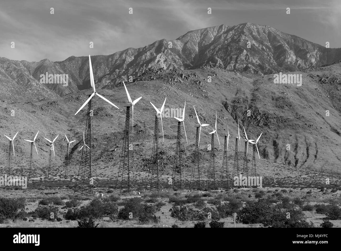 Le turbine eoliche la creazione di fonti di energia rinnovabili su centrali eoliche nel deserto con sfondo di montagna, una tecnologia per spostare lontano da combustibili fossili Foto Stock