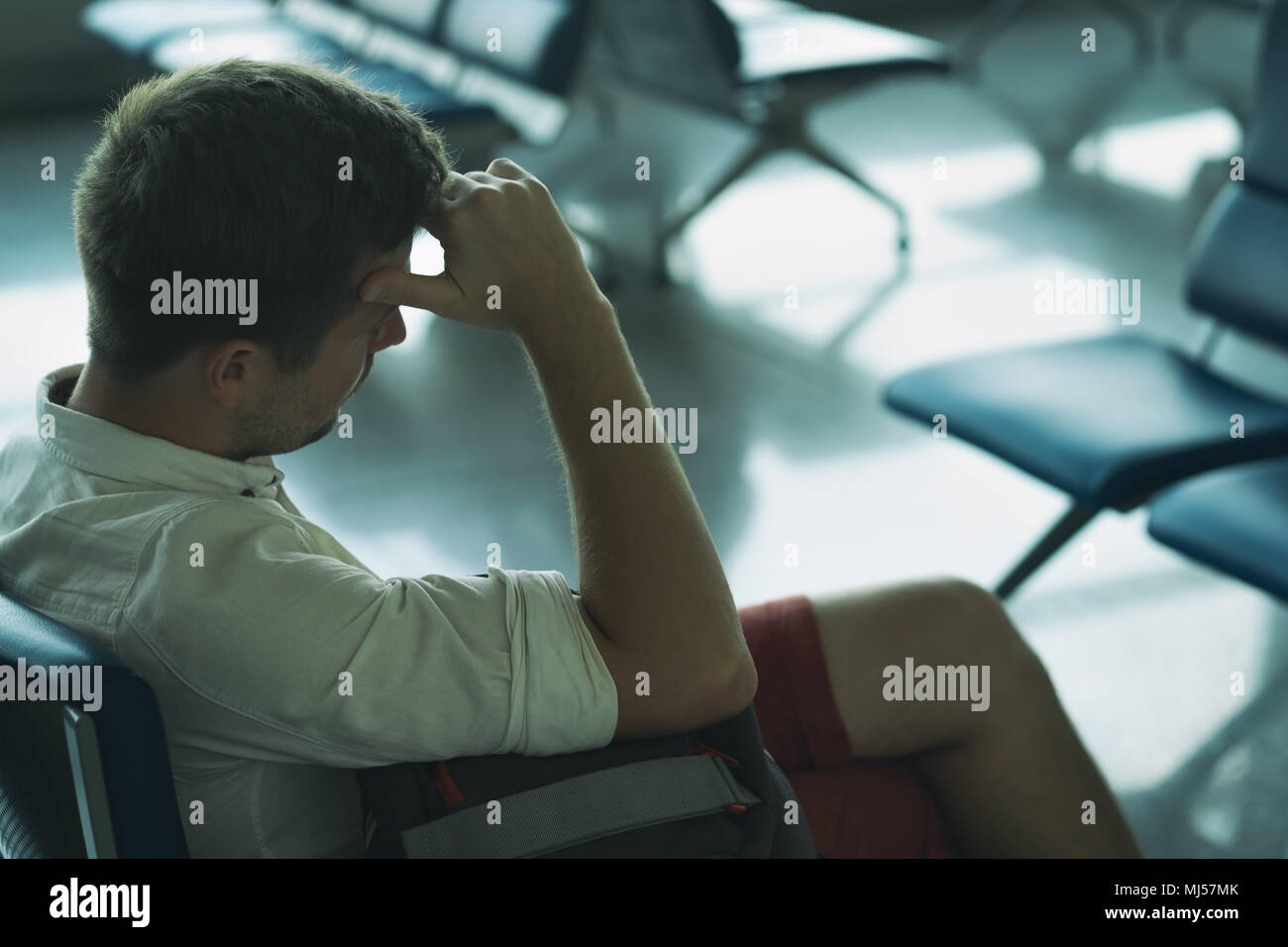 Uomo caucasico è addormentato nella zona lounge presso l'aeroporto. Foto Stock