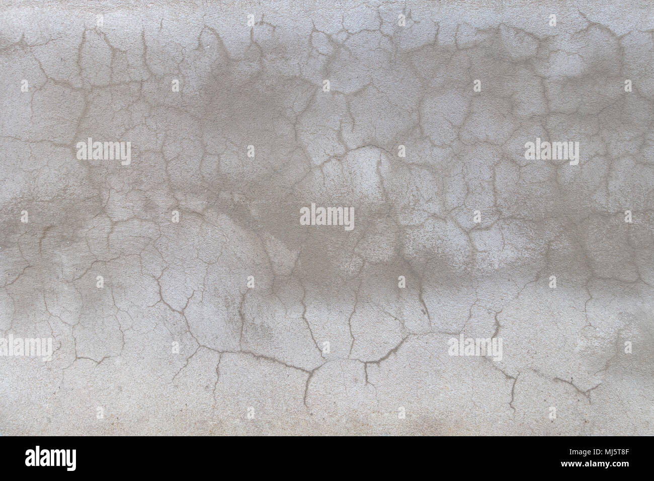 Textured concreat parete con crack casuale e le linee di luce e di aree grigie più scure Foto Stock