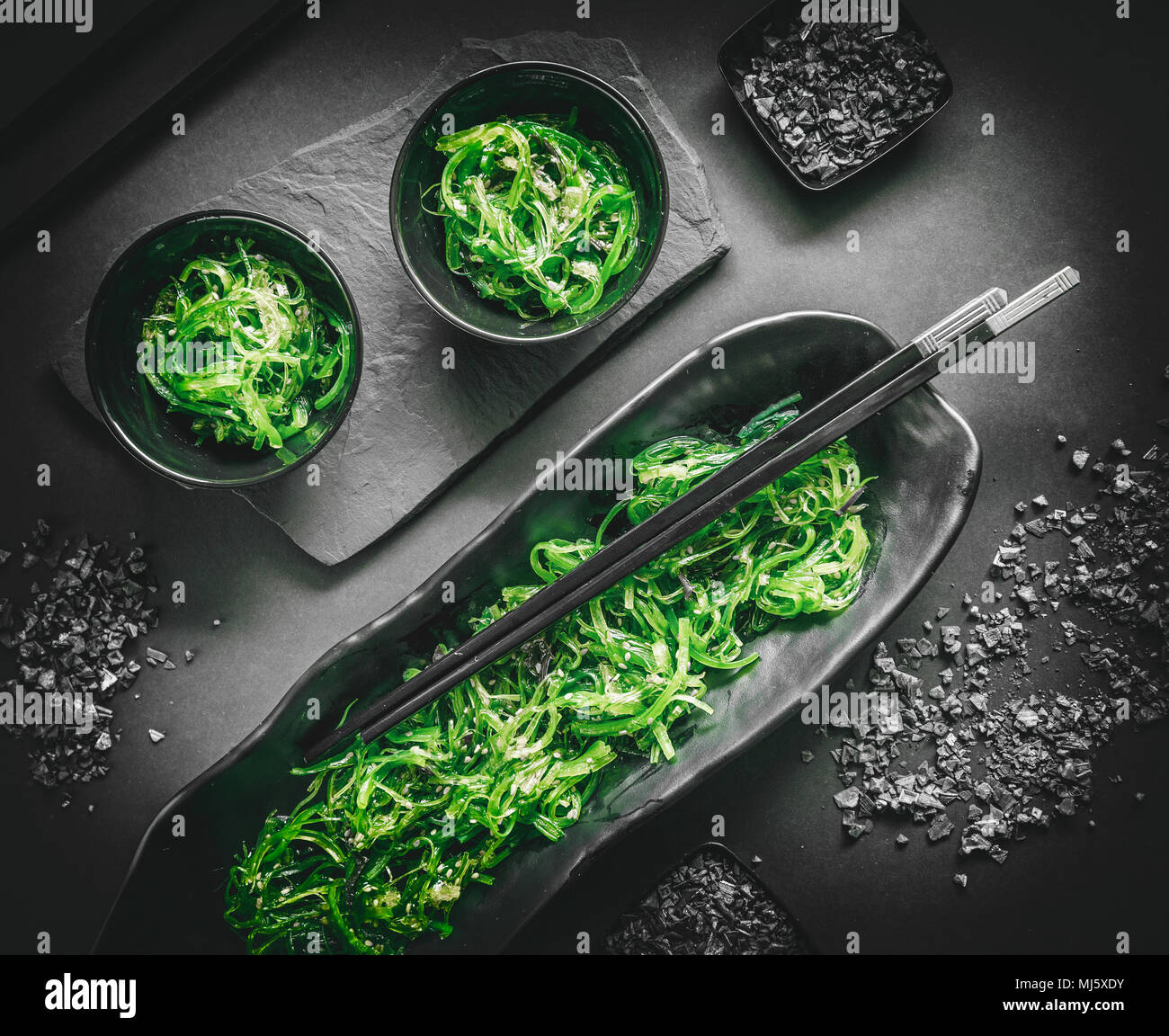Sana insalata di alghe in una ciotola su sfondo nero Foto Stock