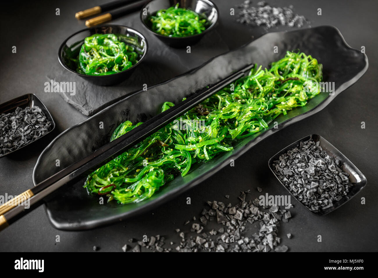 Alghe Wakame insalata servita sulla tradizionale cibo giapponese su nero piatto di ceramica Foto Stock