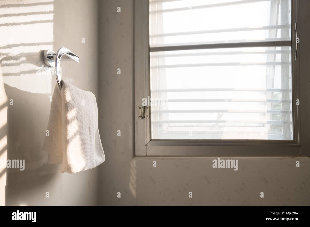 Bianco asciugamano pulito sul ripiano in acciaio in bagno. Foto Stock