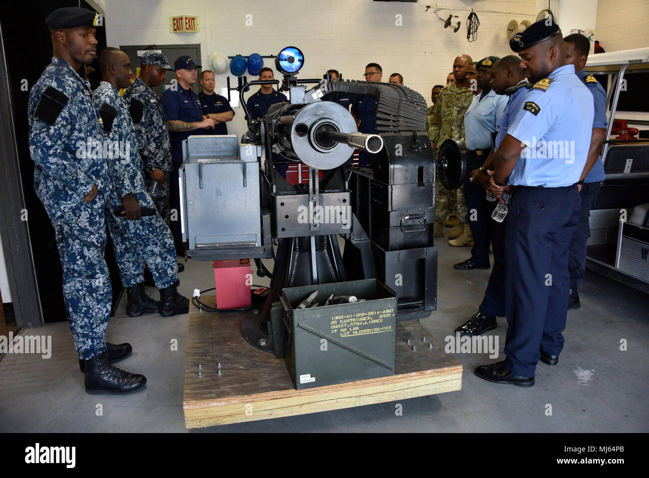 Coast Guard membri spiega le specifiche del Mk38 Macchina marittima Cannon ai membri di più agenzie internazionali durante un tour di strutture a Coast Guard chiave settore ovest, 4 aprile 2018. L'Esperto in materia di Exchange è un evento che coinvolge la Guardia Costiera e più internazionale di agenzie partner per condividere la loro conoscenza sulla superficie Manutenzione asset. La guardia costiera della raccolta di immagini per celebrare il coraggio di impegno di dedizione e di sacrificio di U.S. Forze Armate e personale civile. Foto Stock