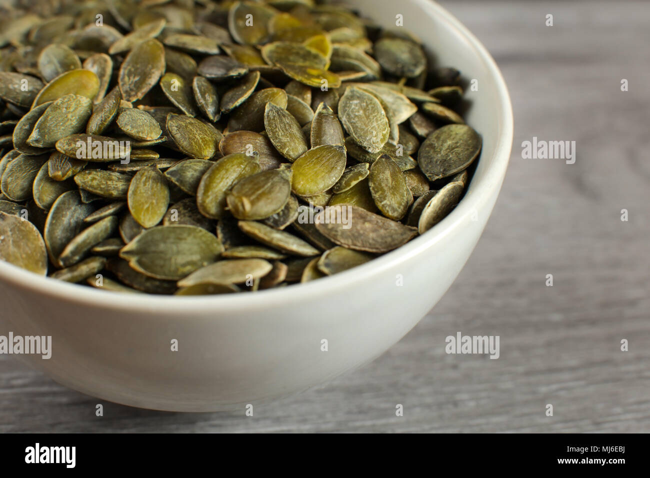 Dettaglio sui crostoni salati semi di zucca collocato in piccolo vaso in ceramica. Foto Stock