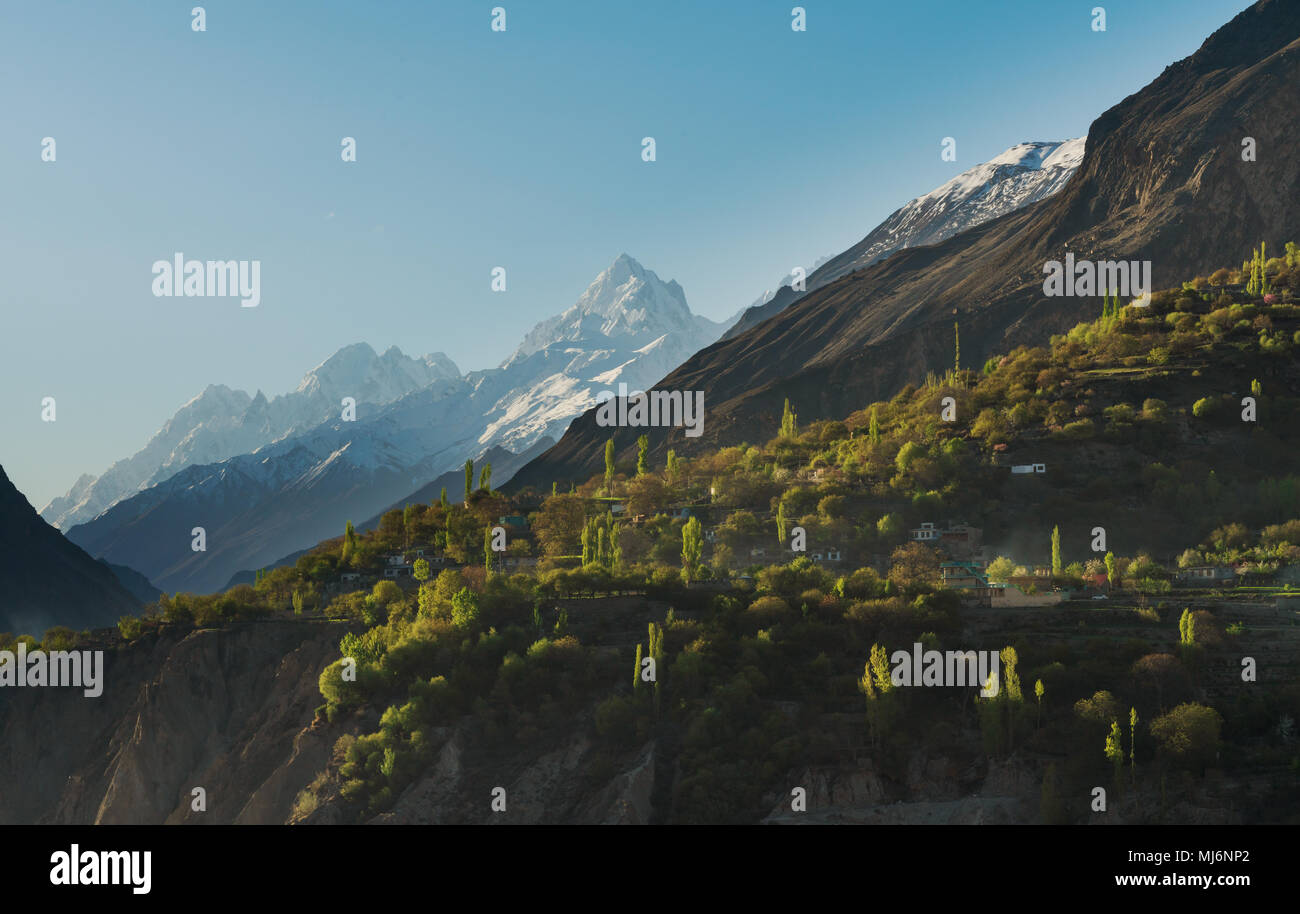 Paesaggio di campagna, neve montagna e borgo rurale con la foresta sulla scogliera di Hunza valley in Pakistan Foto Stock