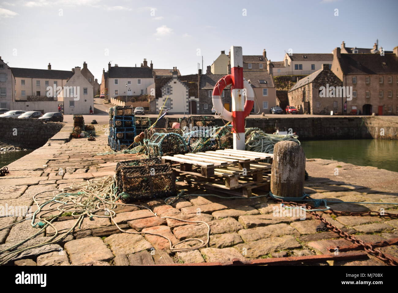 Nasse e salvagente memorizzati sulla banchina a Portsoy Porto Vecchio, Aberdeenshire, Scozia Foto Stock