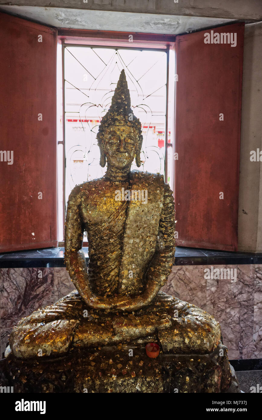 Thaland, Phuket / Thailandia - 11 Aprile 2018 : un giovane uomo è in posa per una fotografia di fronte oro una statua di Buddha nel Wat Phra Tong tempio Foto Stock