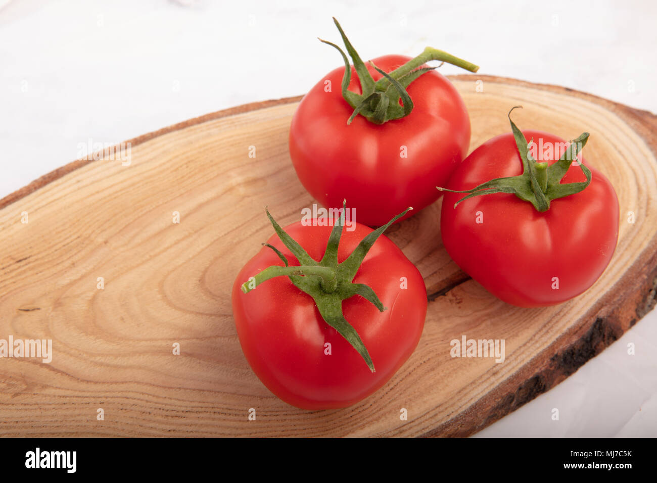 Close up di rossi freschi pomodori deliziosi su una lastra di legno sfondo con posto per il testo Foto Stock